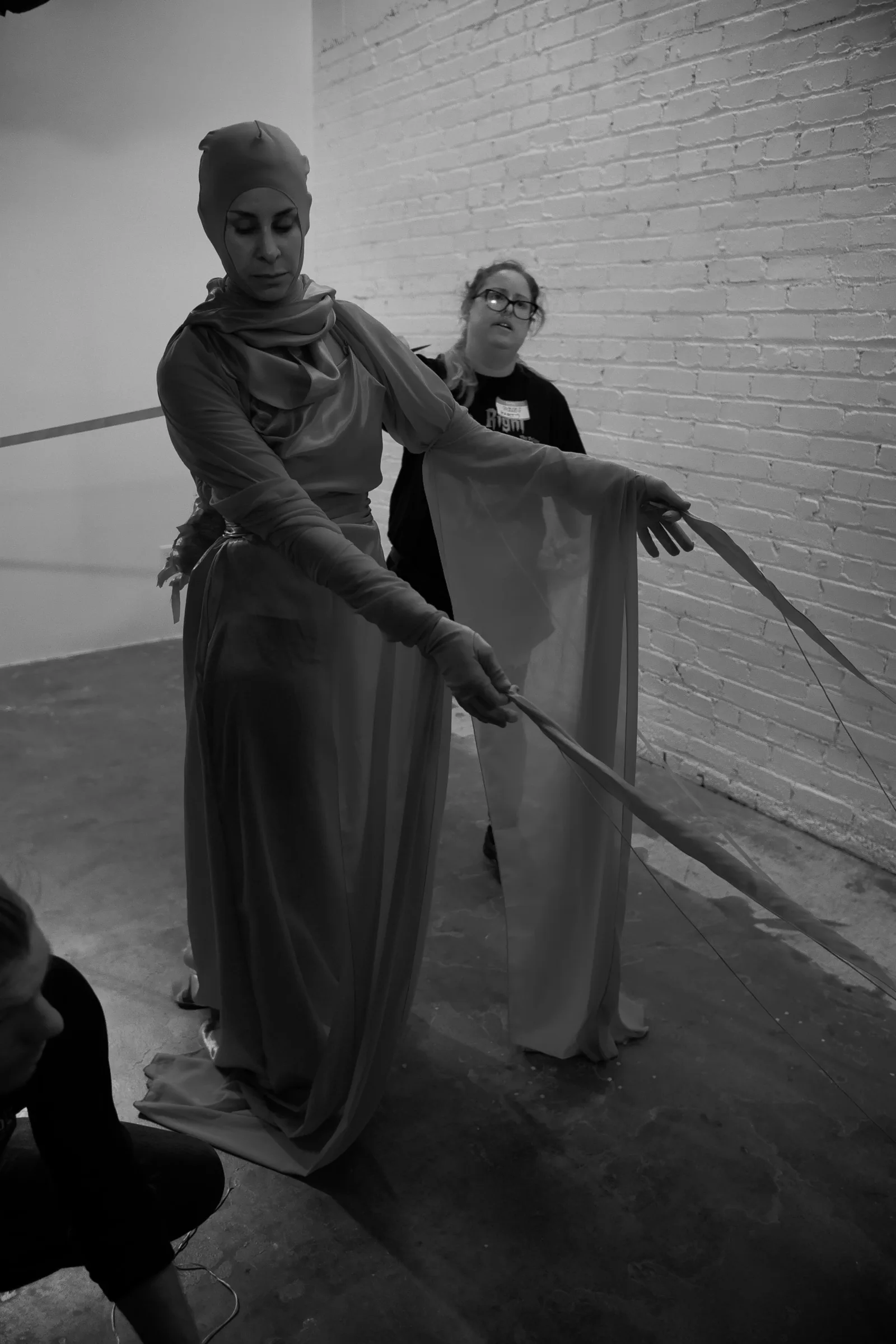 Black and white photo of a costume fitting for the entity