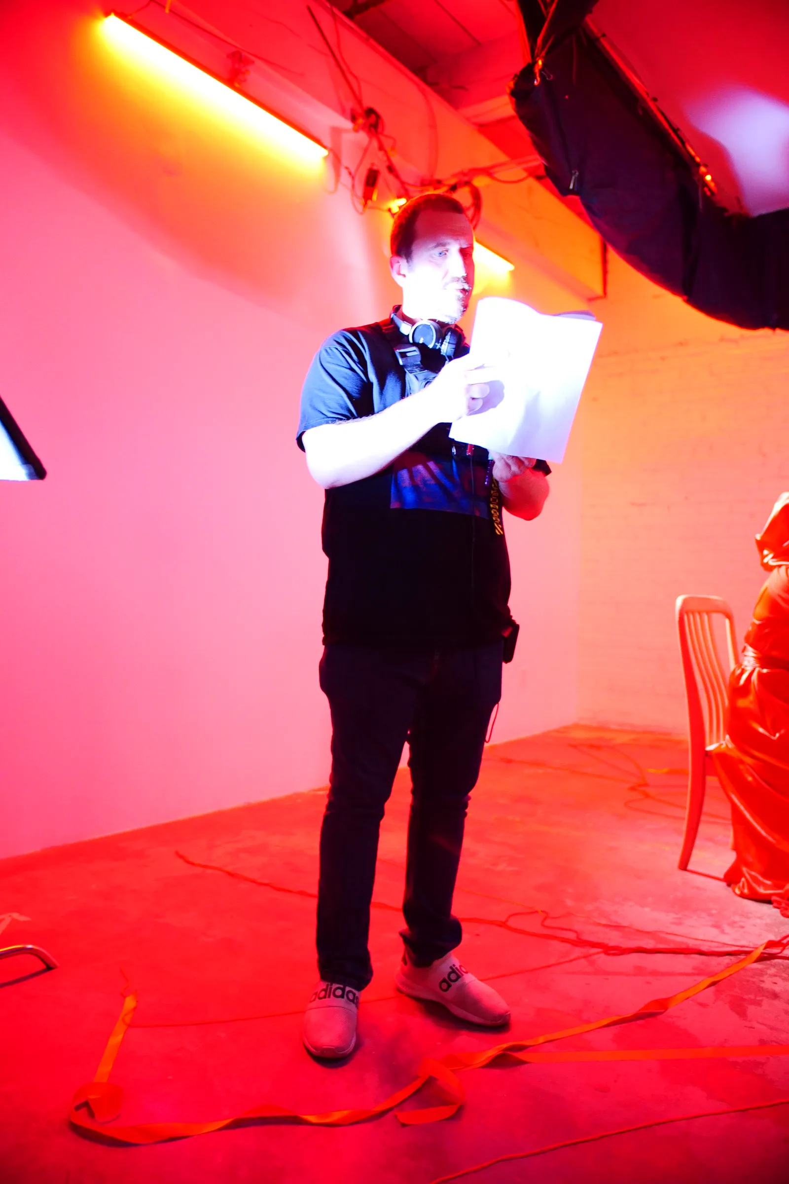 Matt Moeller reading script pages on the red-lit set