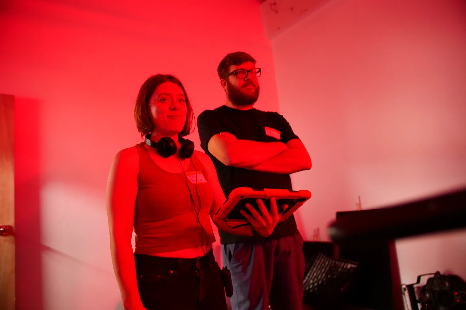 Two crew members watching a take under red light