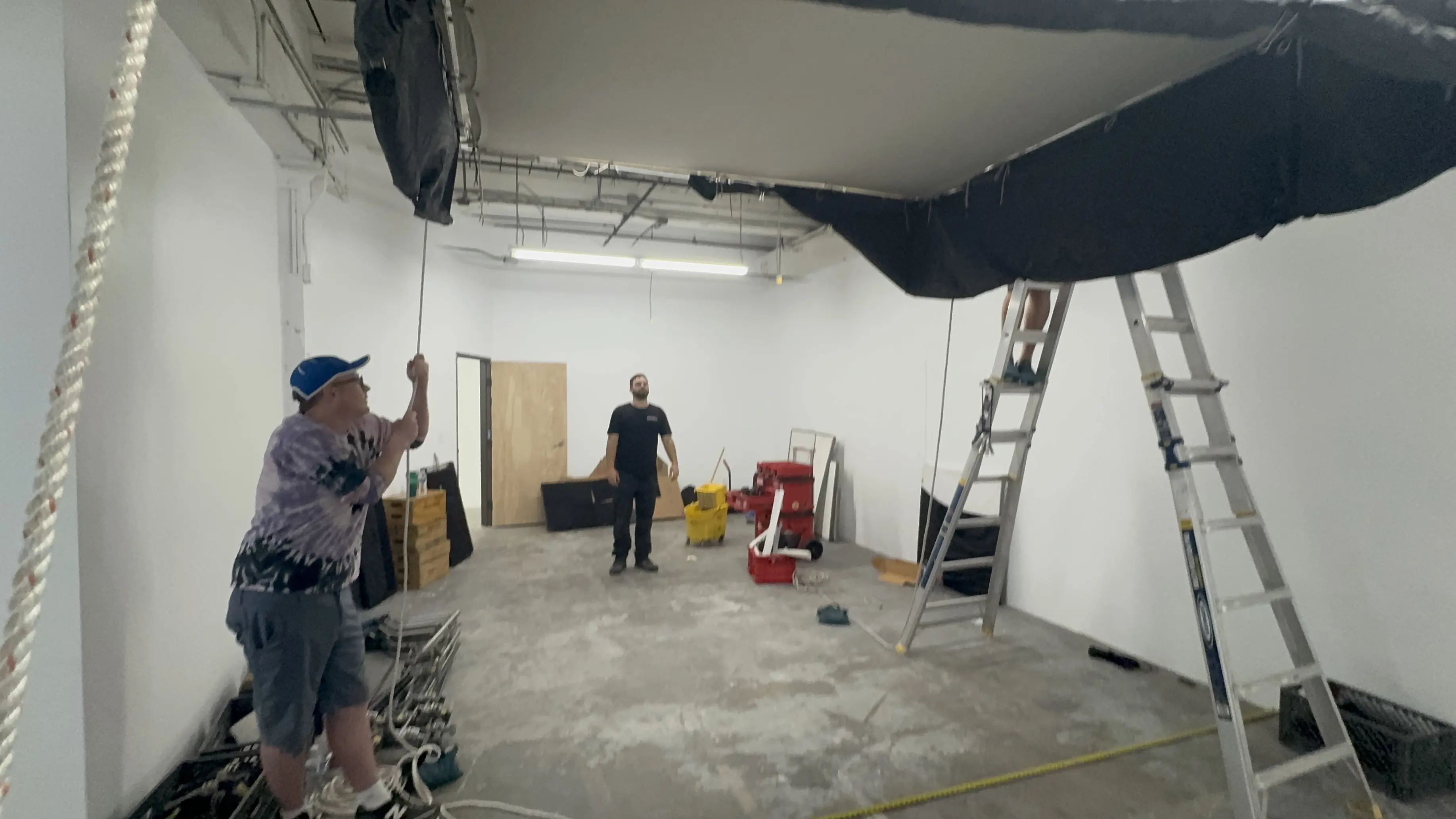 Crew preparing a practical rig inside a white studio space
